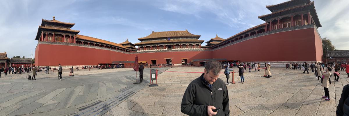 Panorama of the Forbidden City&rsquo;s red Meridian Gate wings, a man checking his phone in the paved plaza